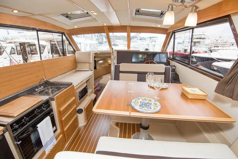 Ruff Life Yacht Photos Pics Manufacturer Provided Image: Interior of 2022 Cutwater C-30 Sedan yacht with dining table and kitchen area.