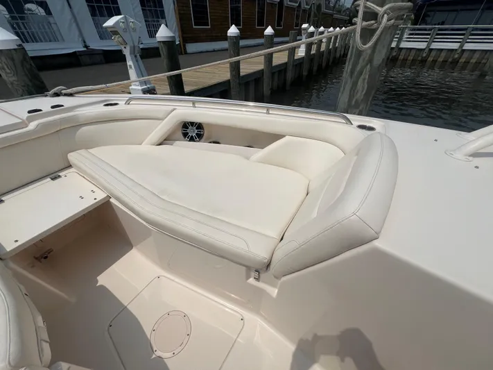  Yacht Photos Pics 2020 Grady-White Freedom 335 boat with beige seating, docked by a wooden pier.