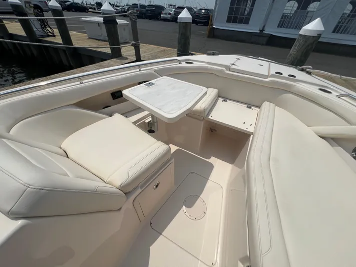  Yacht Photos Pics 2020 Grady-White Freedom 335 boat interior with beige seating and table, docked at marina.