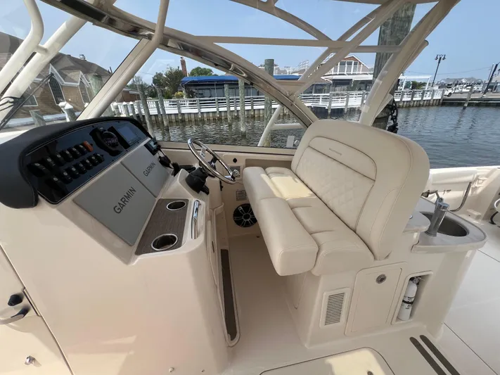  Yacht Photos Pics 2020 Grady-White Freedom 335 boat interior with helm and seating, docked by the water.