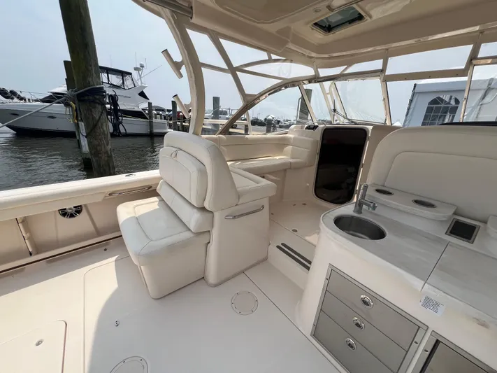  Yacht Photos Pics 2020 Grady-White Freedom 335 boat interior with seating and kitchenette, docked at marina.