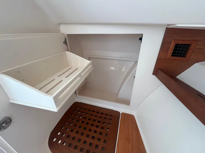  Yacht Photos Pics 2020 Grady-White Freedom 335 interior storage compartment with wooden accents and white shelving.