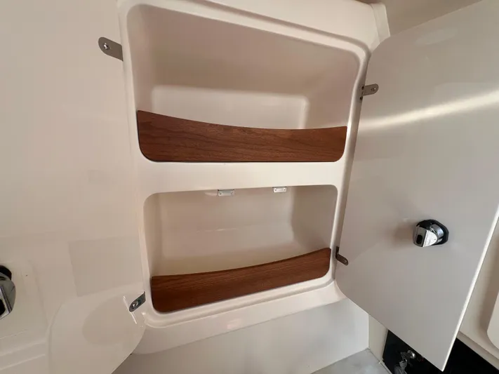  Yacht Photos Pics Cabinet interior of 2020 Grady-White Freedom 335 boat with wooden shelves.