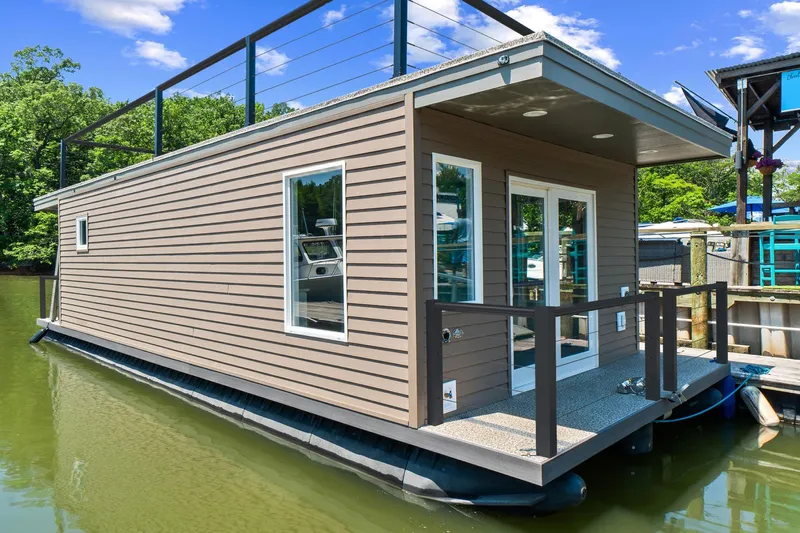  Yacht Photos Pics Modern 2025 Hank's 40 Houseboat with sleek design, docked on a serene lake.