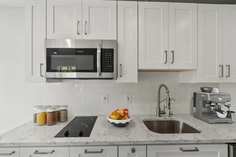  Yacht Photos Pics Modern kitchen in Hank's 40 Houseboat, featuring white cabinets, microwave, and espresso machine.