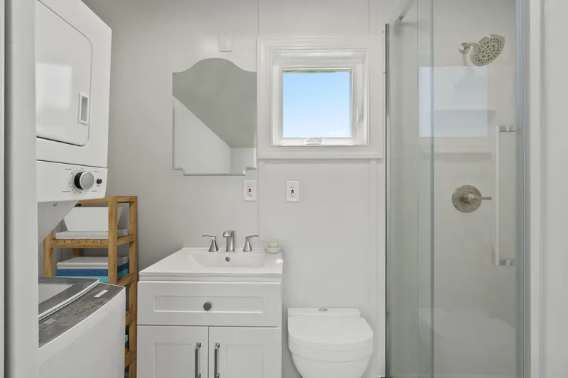  Yacht Photos Pics Modern bathroom in Hank's 40 Houseboat, featuring shower, vanity, and washer-dryer unit, 2025 model.