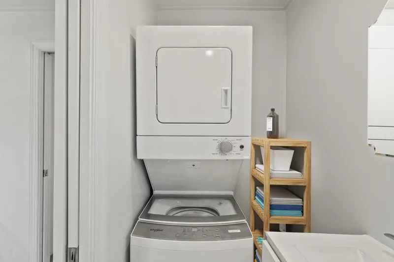  Yacht Photos Pics Stacked washer and dryer in Hank's 40 Houseboat, 2025 model, with wooden shelving.