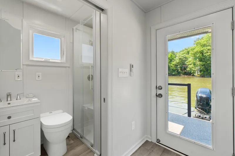  Yacht Photos Pics Modern bathroom on Hank's 40 Houseboat, 2025, with river view through glass door.