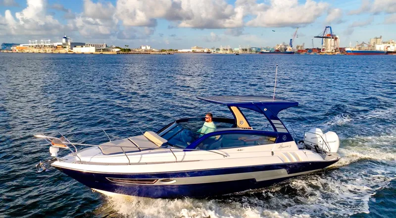  Yacht Photos Pics 2024 Hanover 305 boat cruising on open water under a partly cloudy sky.