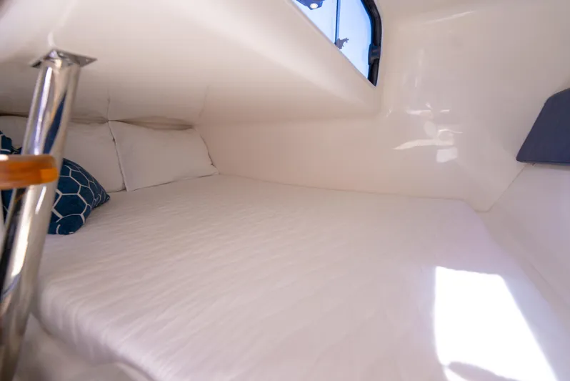  Yacht Photos Pics Cozy cabin interior of 2024 Hanover 305 boat with white bedding and pillows.