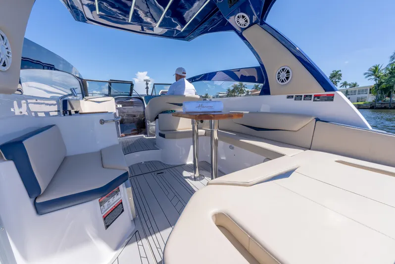  Yacht Photos Pics Luxurious 2024 Hanover 305 boat interior with seating and table, under a clear blue sky.