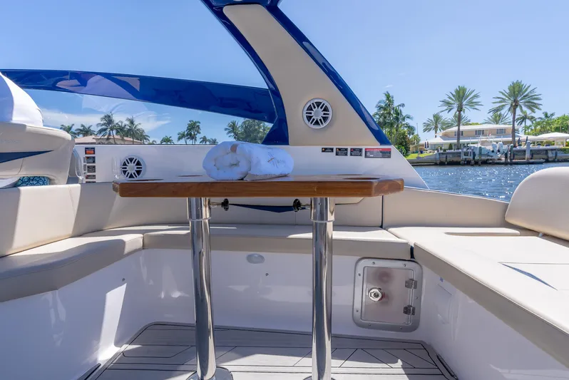  Yacht Photos Pics Luxurious 2024 Hanover 305 boat interior with wooden table, waterfront view, and palm trees.