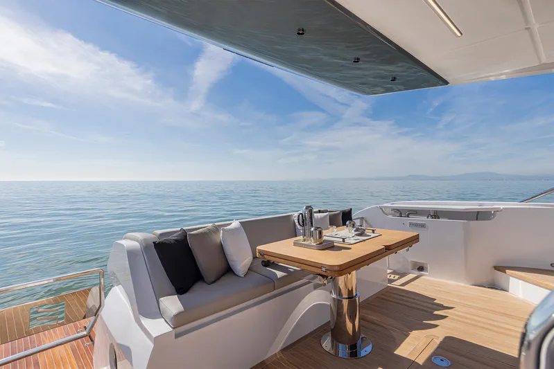  Yacht Photos Pics Luxurious 2025 Ferretti Yachts 580 deck with seating, table, and ocean view.