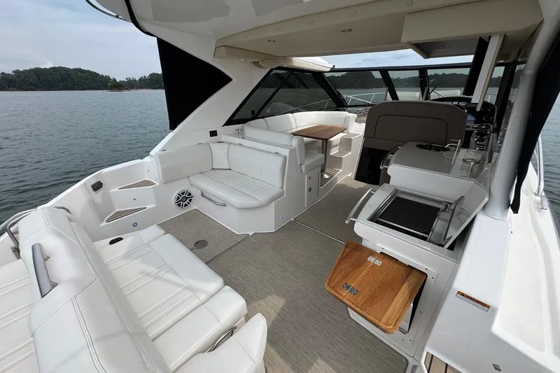 Absolutely Yacht Photos Pics 2017 Regal 42 Sport Coupe interior with white seating, wooden table, and lake view.