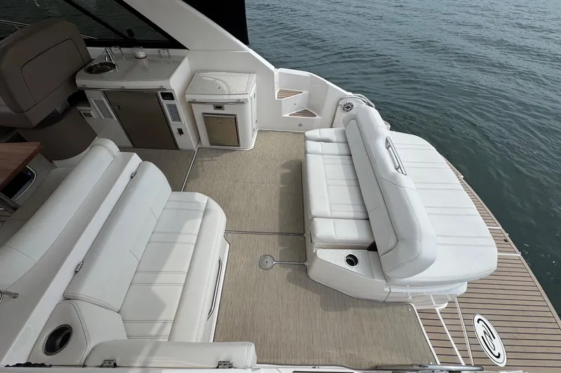 Absolutely Yacht Photos Pics 2017 Regal 42 Sport Coupe yacht deck with white seating and kitchenette by the water.