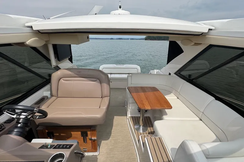 Absolutely Yacht Photos Pics 2017 Regal 42 Sport Coupe interior with seating and table, overlooking serene water.