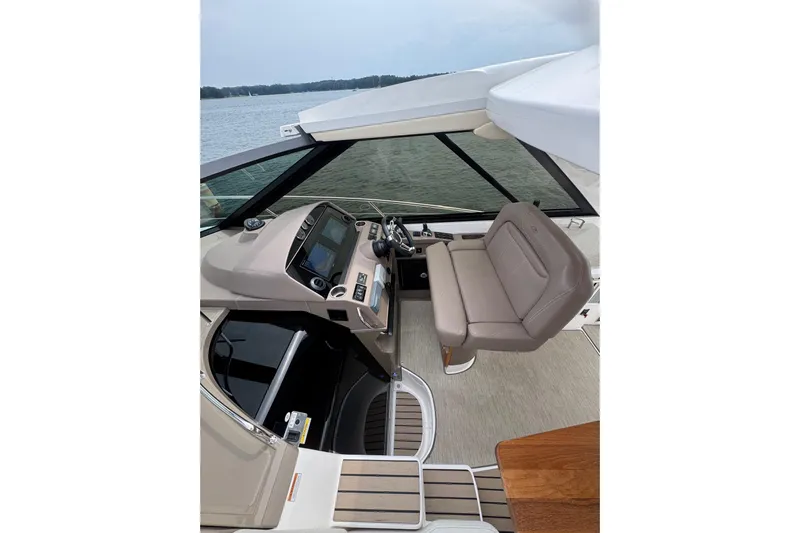 Absolutely Yacht Photos Pics 2017 Regal 42 Sport Coupe cockpit with modern controls and seating, overlooking serene waters.