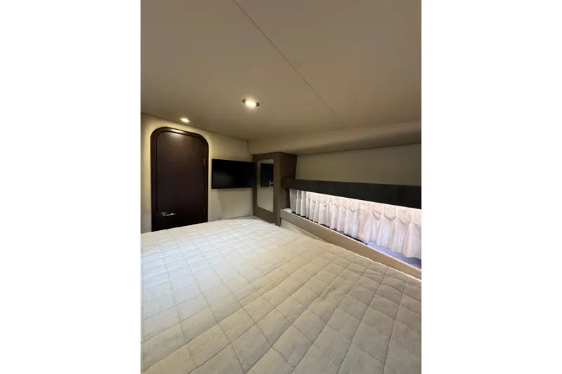 Absolutely Yacht Photos Pics Interior cabin of 2017 Regal 42 Sport Coupe with bed, TV, and window.