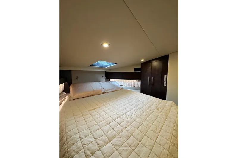 Absolutely Yacht Photos Pics Luxurious bedroom interior of 2017 Regal 42 Sport Coupe yacht with skylight and cozy bedding.