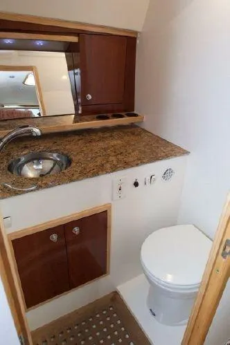 Maripal Yacht Photos Pics 2008 Contender 38 Express boat bathroom with granite countertop and wooden cabinetry.