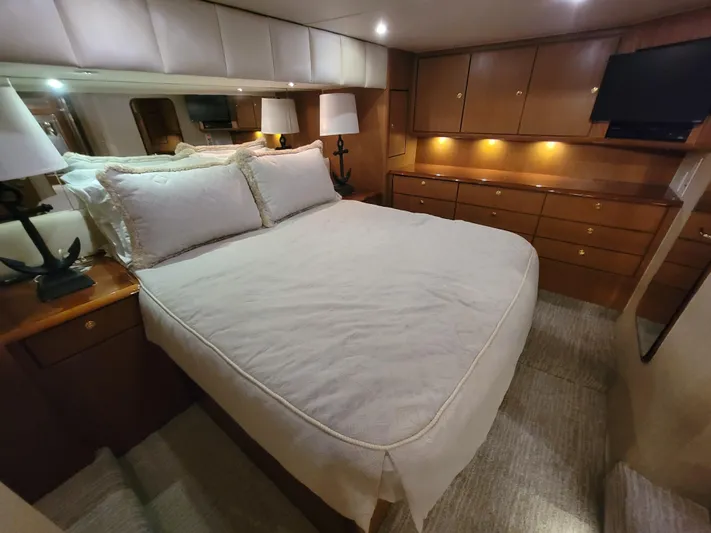  Yacht Photos Pics Luxurious bedroom in 2001 Ocean Yachts 56 Super Sport with ample storage and cozy lighting.