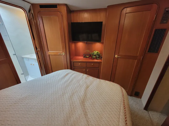  Yacht Photos Pics Bedroom interior of 2001 Ocean Yachts 56 Super Sport with TV and wooden cabinetry.