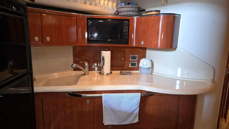 One More Time Yacht Photos Pics 2004 Sea Ray 380 Sundancer kitchen with wood cabinets, microwave, and sink.