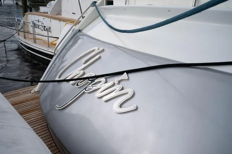 Chopin Yacht Photos Pics 2007 Pershing 62' yacht with "Chopin" nameplate, docked beside another vessel.