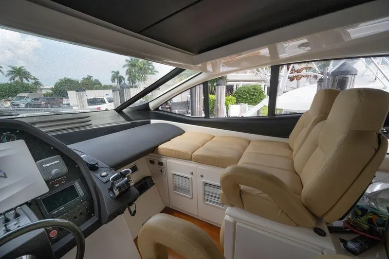 Chopin Yacht Photos Pics Interior of a 2007 Pershing 62' yacht with beige seating and control panel.