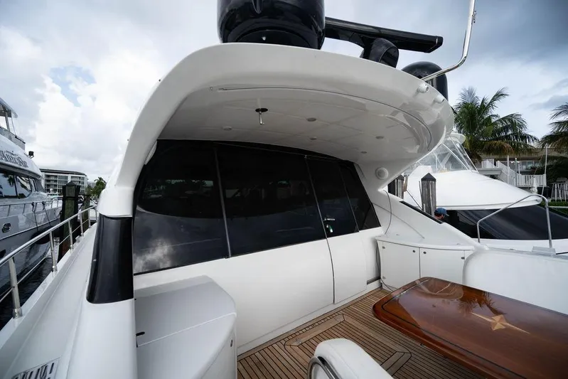 Chopin Yacht Photos Pics 2007 Pershing 62' yacht with sleek design, docked near palm trees and other boats.