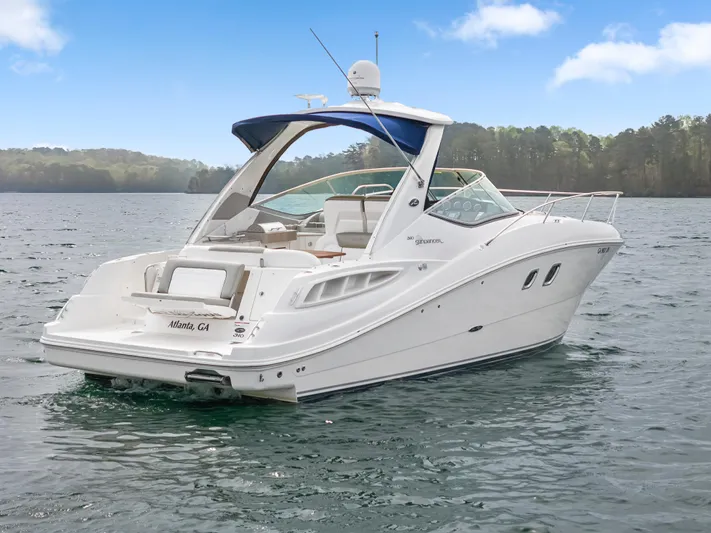 Beau Dacious Yacht Photos Pics 2007 Sea Ray 310 Sundancer boat on a serene lake with forested background.