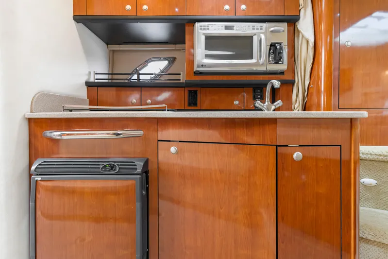 Beau Dacious Yacht Photos Pics 2007 Sea Ray 310 Sundancer galley with wood cabinetry, microwave, and compact fridge.