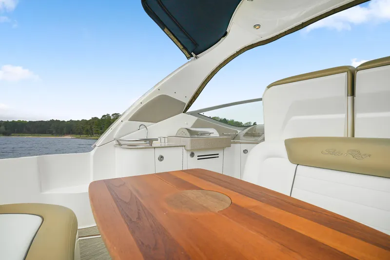 Beau Dacious Yacht Photos Pics 2007 Sea Ray 310 Sundancer interior with wooden table and seating, overlooking water.