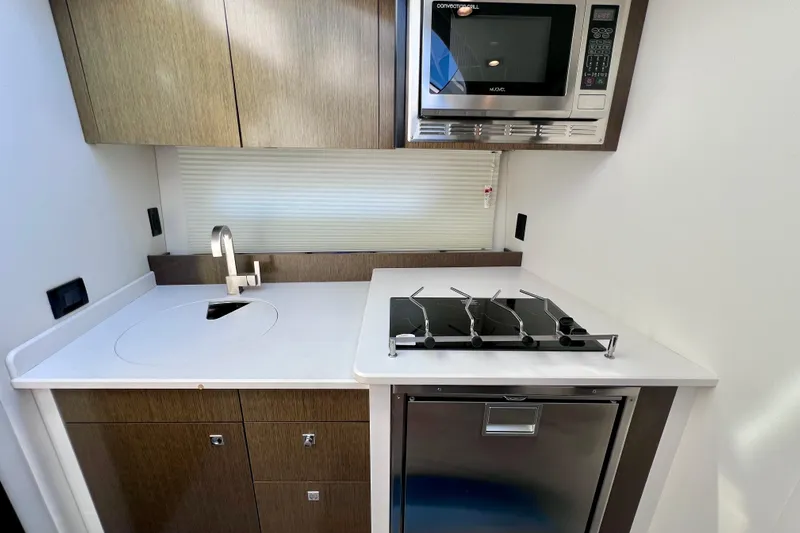  Yacht Photos Pics 2018 Cruisers Yachts 41 Cantius kitchen with stove, sink, and microwave.
