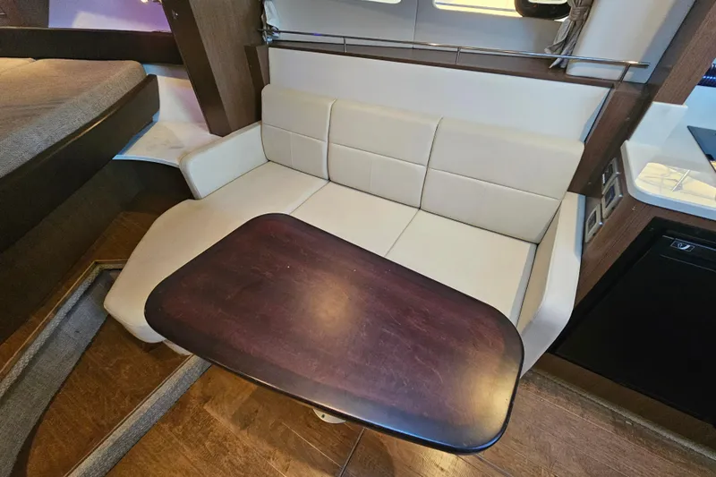 Levon II Yacht Photos Pics 2017 Sea Ray Sundancer 350 Coupe interior with beige seating and wooden table.