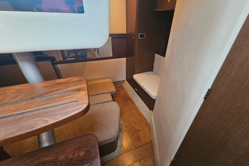 Levon II Yacht Photos Pics Interior of 2017 Sea Ray Sundancer 350 Coupe with wooden table and seating area.