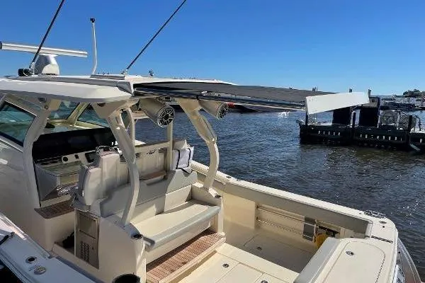  Yacht Photos Pics 2019 Scout 380 LXF boat with spacious deck and seating, docked by the water.