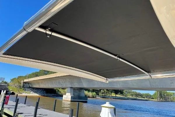  Yacht Photos Pics 2019 Scout 380 LXF boat with extended canopy under a bridge on a sunny day.