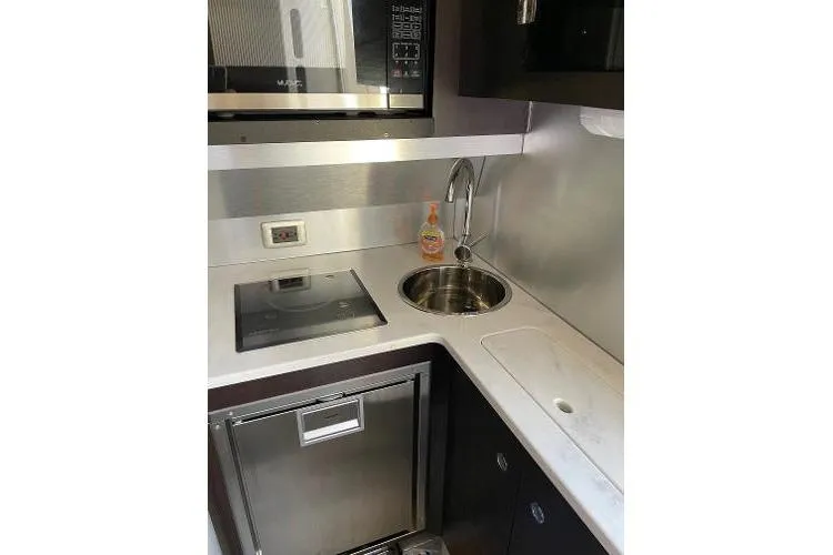  Yacht Photos Pics Compact kitchen area in a 2019 Scout 380 LXF boat, featuring modern appliances.