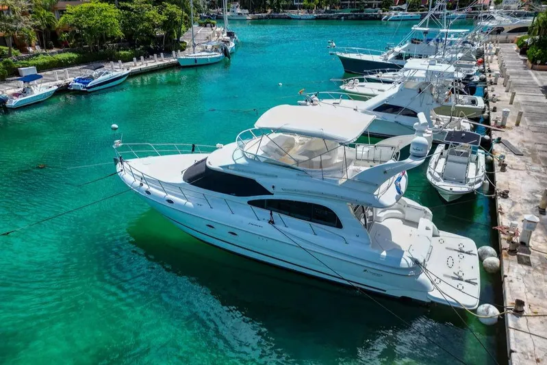  Yacht Photos Pics 2001 Cruisers Yachts 5000 Sedan Sport docked in a vibrant marina.
