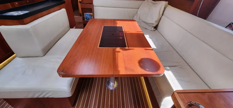 Avalon Sunset Yacht Photos Pics Interior of a 2016 Hanse 505 yacht with wooden table and beige seating.