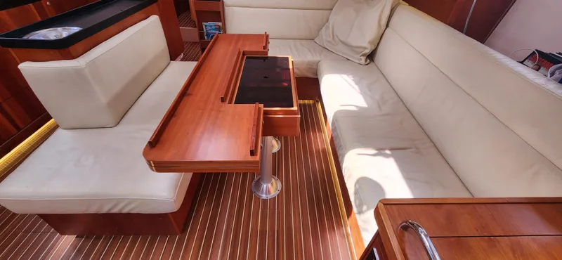 Avalon Sunset Yacht Photos Pics Luxurious interior of 2016 Hanse 505 yacht with wooden table and cream seating.