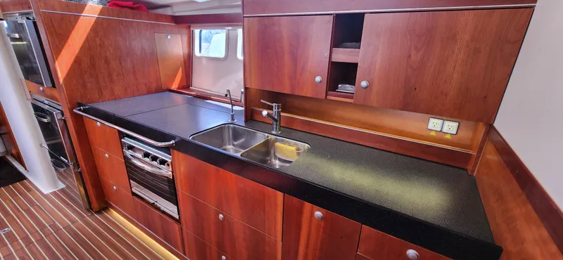 Avalon Sunset Yacht Photos Pics Luxurious 2016 Hanse 505 yacht kitchen with wooden cabinetry and modern appliances.