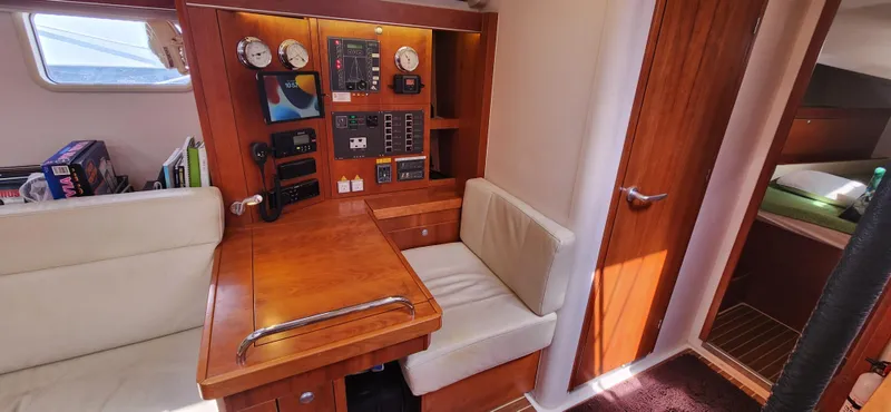 Avalon Sunset Yacht Photos Pics Navigation station inside 2016 Hanse 505 yacht with wooden finish and seating area.