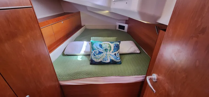 Avalon Sunset Yacht Photos Pics Cozy cabin interior of 2016 Hanse 505 yacht with green bedding and decorative pillows.