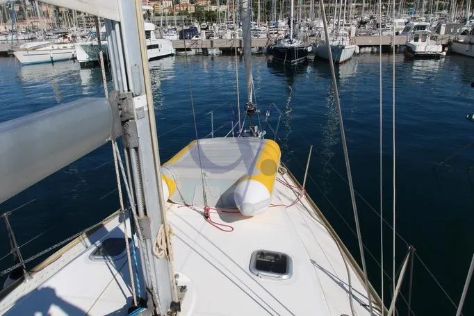  Yacht Photos Pics 2004 Jeanneau Sun Odyssey 40.3 sailboat docked in a marina, featuring a yellow dinghy on deck.