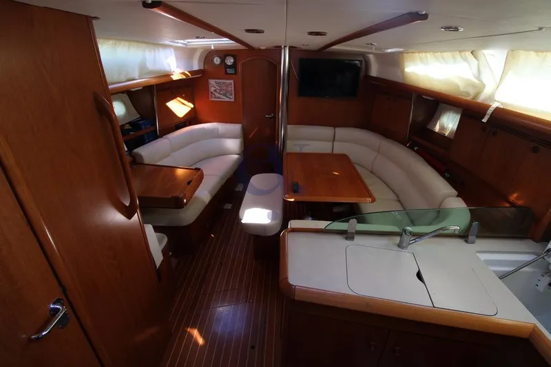  Yacht Photos Pics Interior of 2004 Jeanneau Sun Odyssey 40.3 yacht with elegant wood finish and cozy seating.