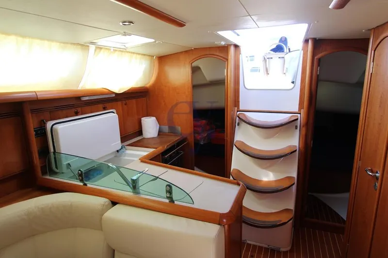  Yacht Photos Pics Interior of 2004 Jeanneau Sun Odyssey 40.3 yacht with wooden cabinetry and seating.