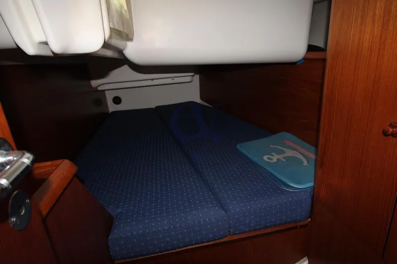  Yacht Photos Pics Cozy cabin interior of 2004 Jeanneau Sun Odyssey 40.3 sailboat with blue bedding.