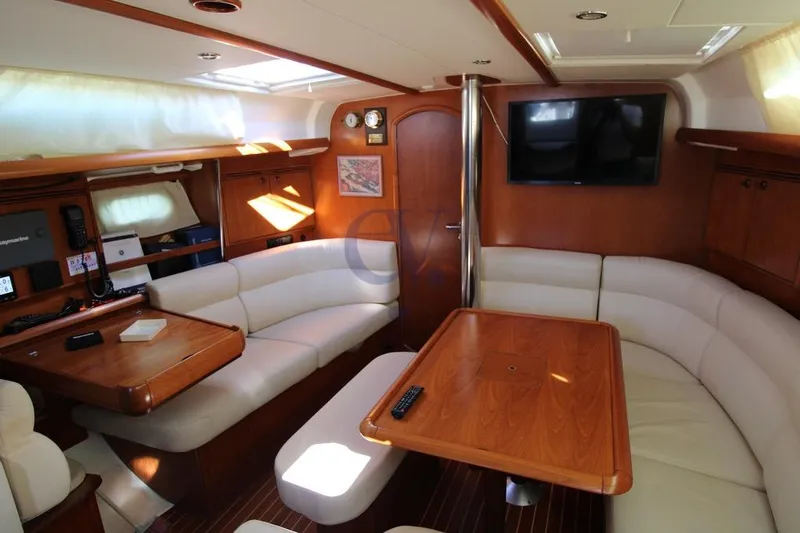  Yacht Photos Pics Interior of 2004 Jeanneau Sun Odyssey 40.3 yacht with elegant seating and wooden finishes.